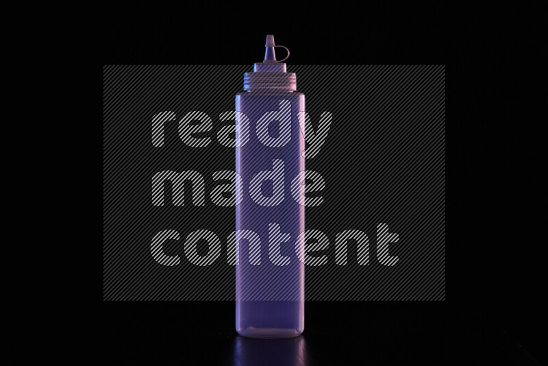 A squeeze bottle with colored rim light against black background