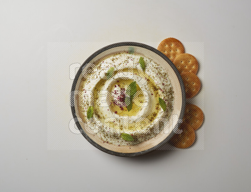 Lebnah garnished with zaater, mint & sumak in a pottery plate on a white background