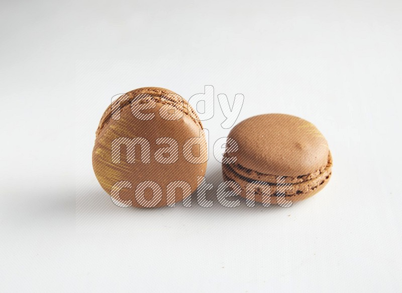 45º Shot of two Brown Coffee macarons on white background