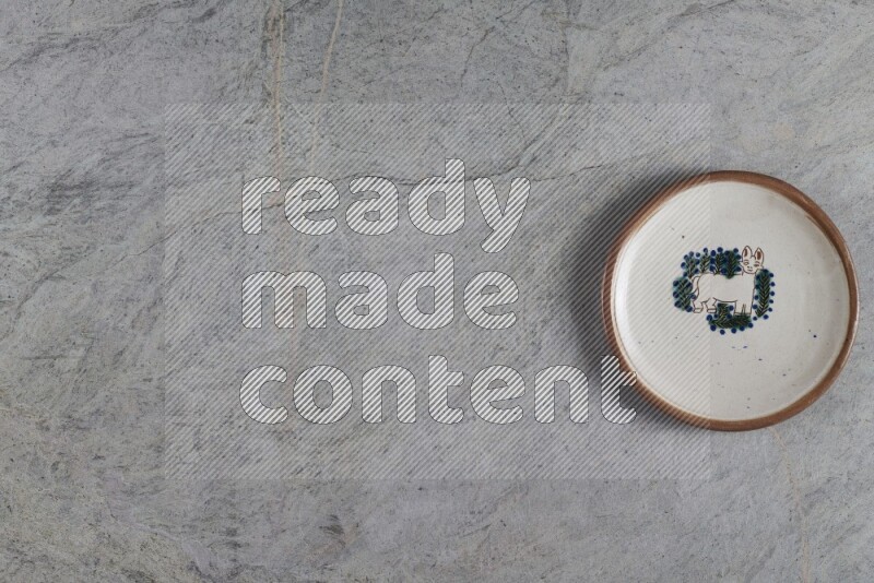 صحن فخاري مزخرف على خلفية من الرخام الرمادي