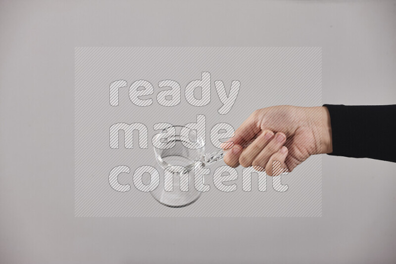 امرأة ترتدي عباءة سوداء تحمل أدوات زجاجية مختلفة في أوضاع متعددة