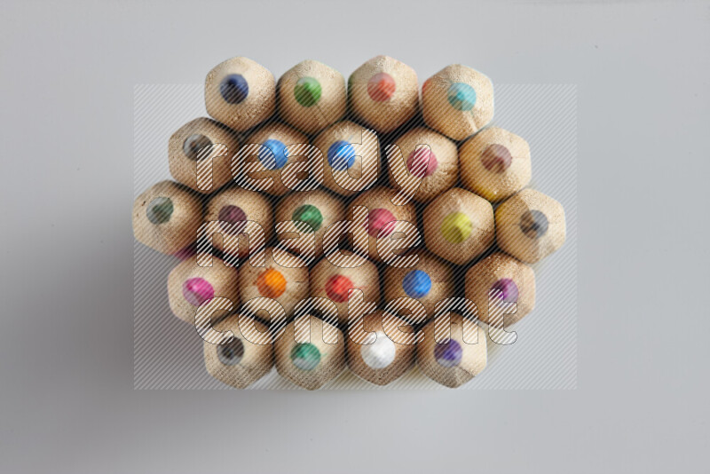 تظهر الصورة لقطة علوية لأقلام تلوين خشبية علي خلفية رمادية