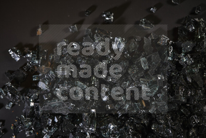 قطع زجاج سوداء شفافة متناثرة على خلفية سوداء