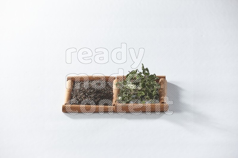 2 squares of cinnamon sticks full of black tea and dried mint leaves on white flooring