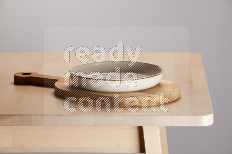 multi colored plate placed on a  wooden oval cutting board on the edge of wooden table