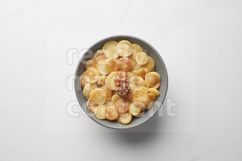 Top-view shot of walnut cereal pancakes in a round bowl on white background