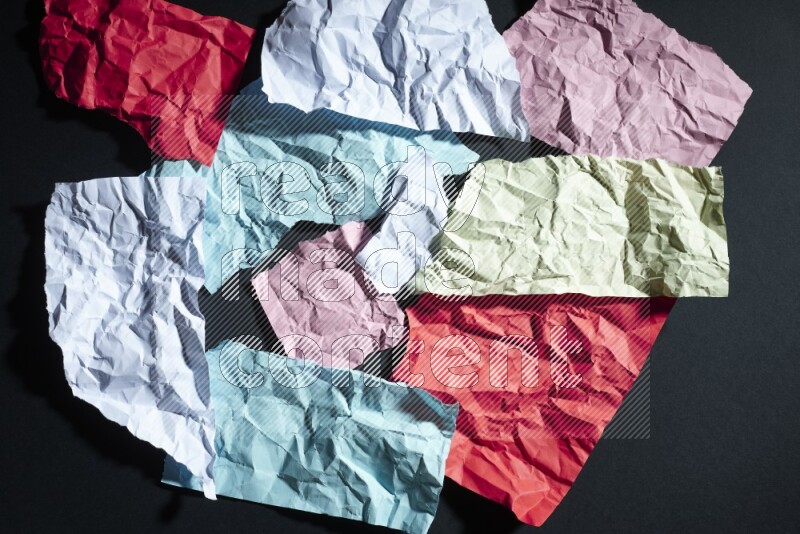 Crumpled multicolored paper on black background
