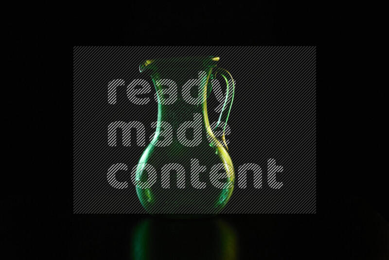 Glassware with rim light in green and yellow against black background