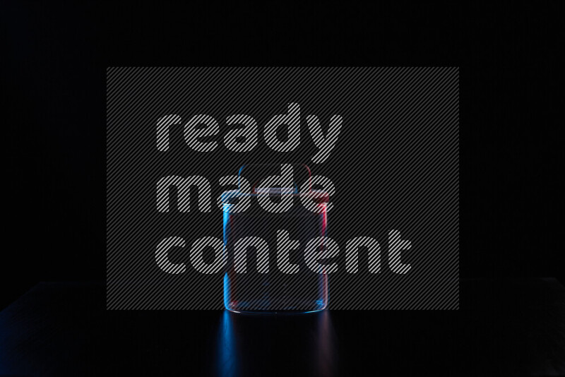 Glassware with rim light in red and blue against black background