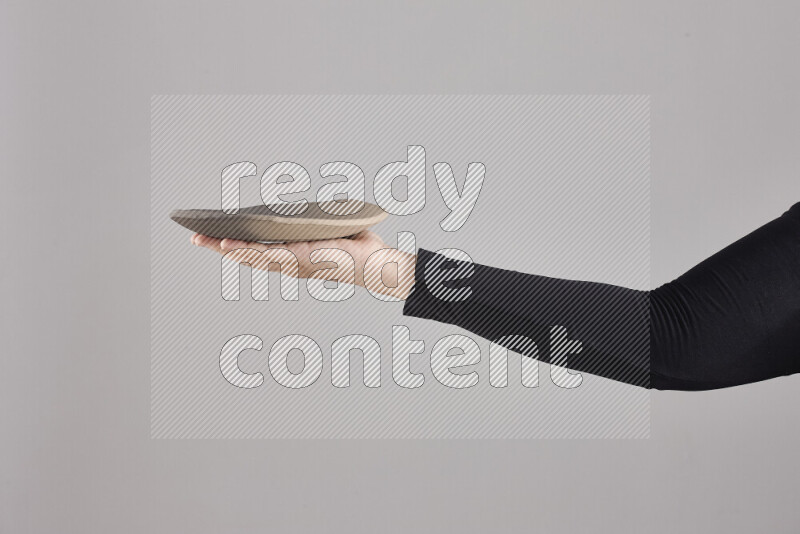 امرأة ترتدي عباءة سوداء تحمل أدوات فخارية مختلفة في أوضاع متعددة