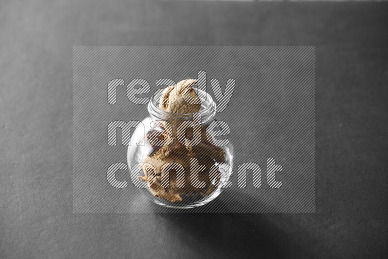 زنجبيل مجفف في وعاء زجاجي علي خلفية سوداء