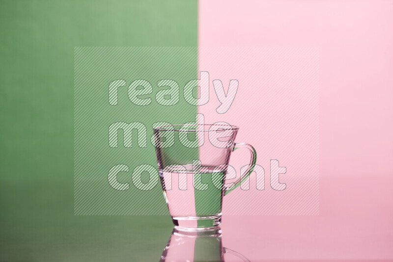 The image features a clear glassware filled with water, set against green and rose background