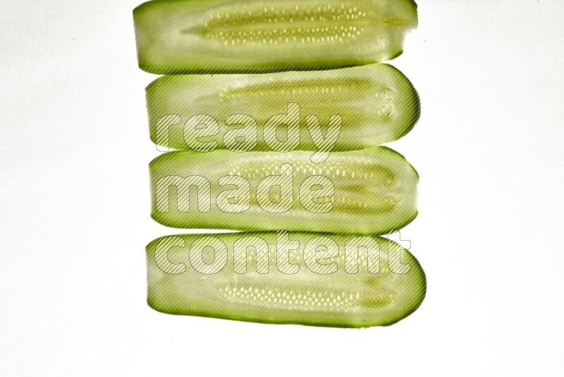 Zucchini slices on illuminated white background