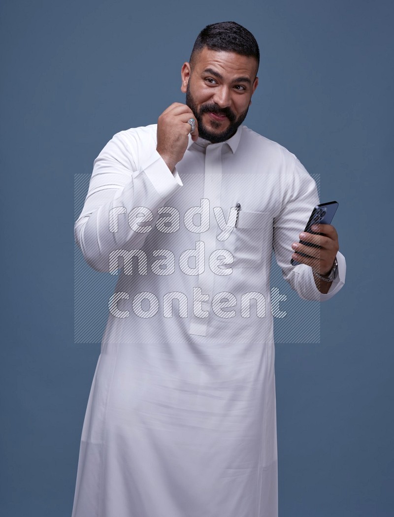 رجل سعودي يرتدي ثوب ابيض ويستخدم جواله