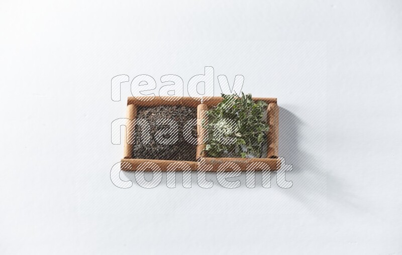 2 squares of cinnamon sticks full of black tea and dried mint leaves on white flooring