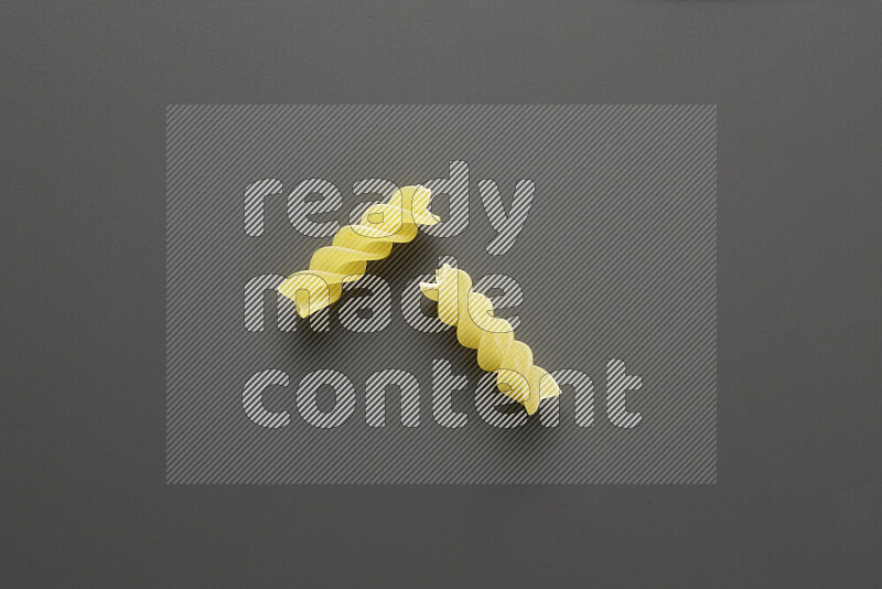 Fusilli pasta on grey background