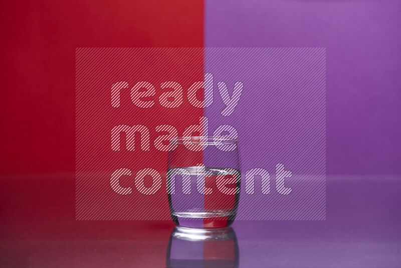 The image features a clear glassware filled with water, set against red and purple background