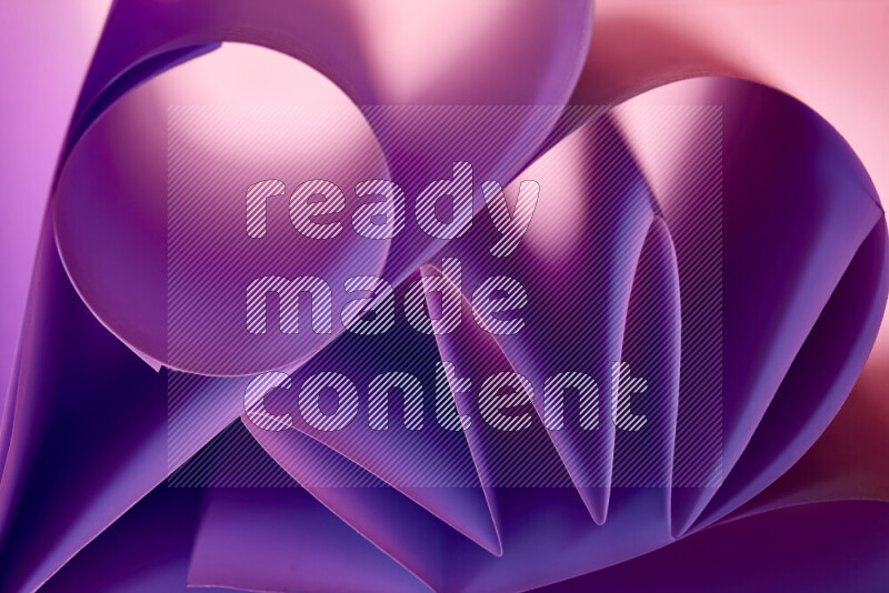 An artistic display of paper folds creating a harmonious blend of geometric shapes, highlighted by soft lighting in purple tones