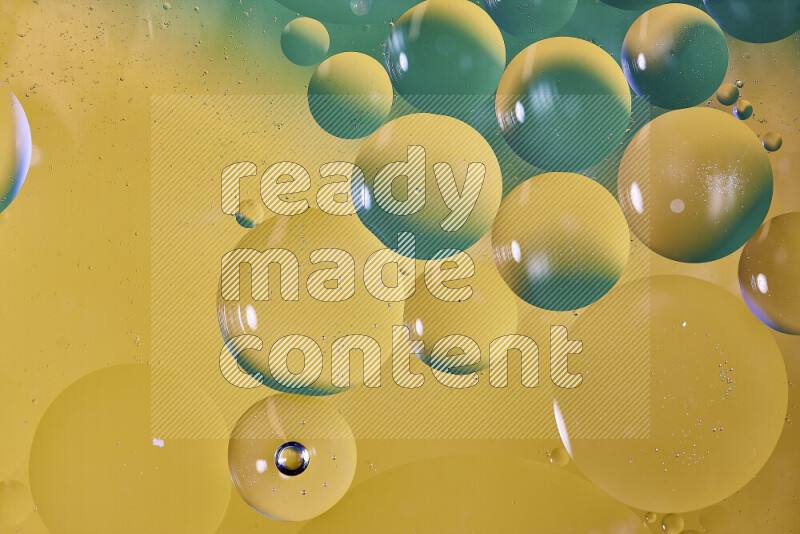 Close-ups of abstract oil bubbles on water surface in shades of green and yellow