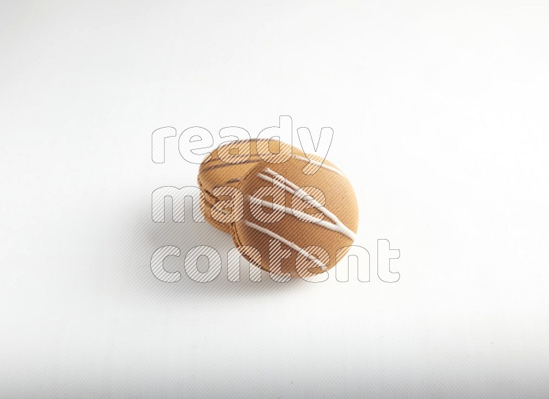 45º Shot of of two assorted Brown Irish Cream, and light brown  Almond Cream macarons on white background