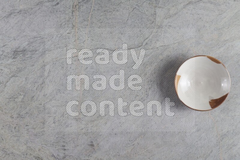 A multicolored pottery plate on grey marble background