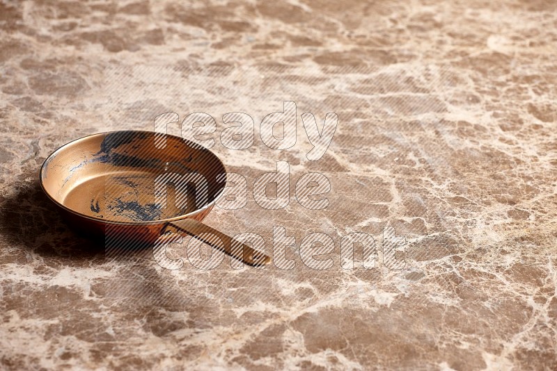 Small Copper Pan on Beige Marble Flooring, 45 degrees