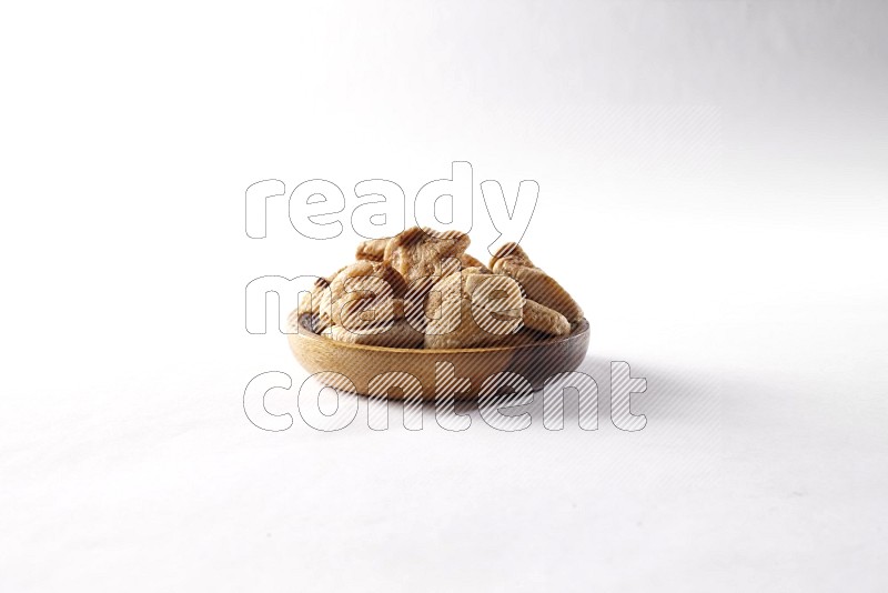 Dried figs in a wooden bowl on white background