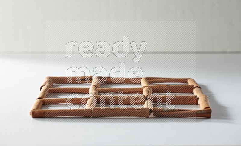 9 empty squares of cinnamon sticks on white flooring
