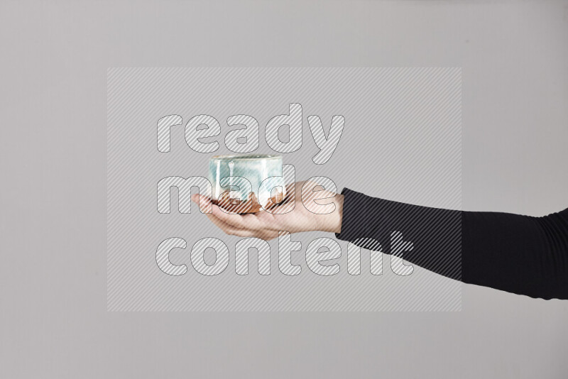A woman in black abaya holding different pottery essentials in different positions