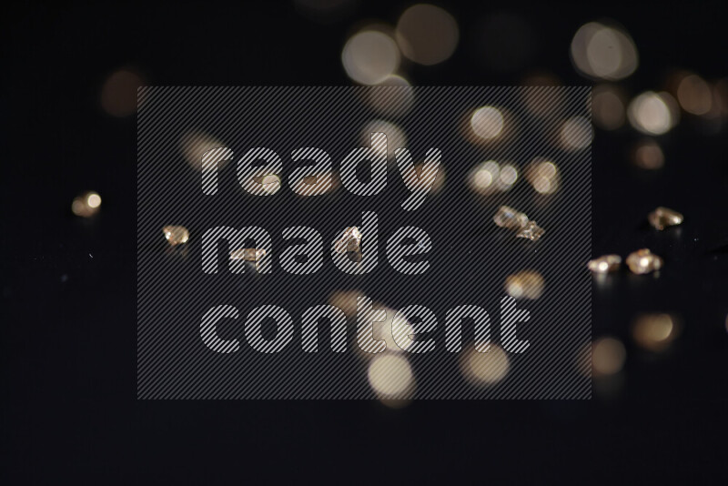 قطع زجاجية ذهبية لامعة متناثرة على خلفية سوداء