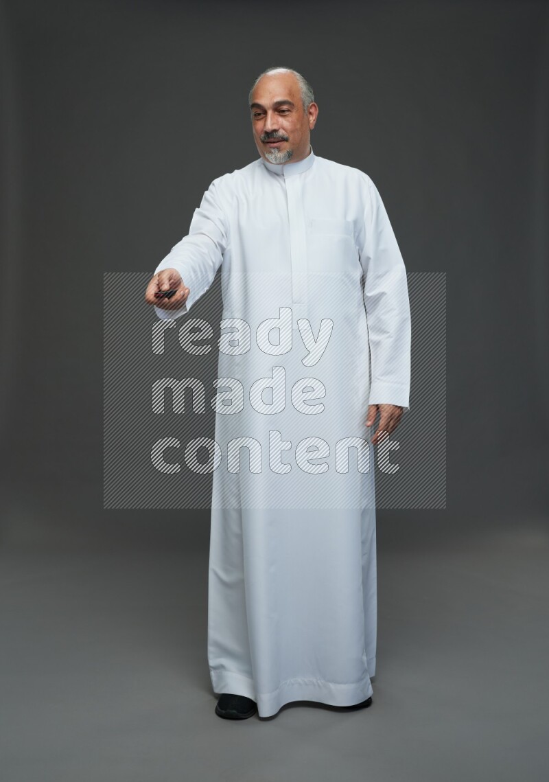 Saudi man without shomag Standing holding car key on gray background