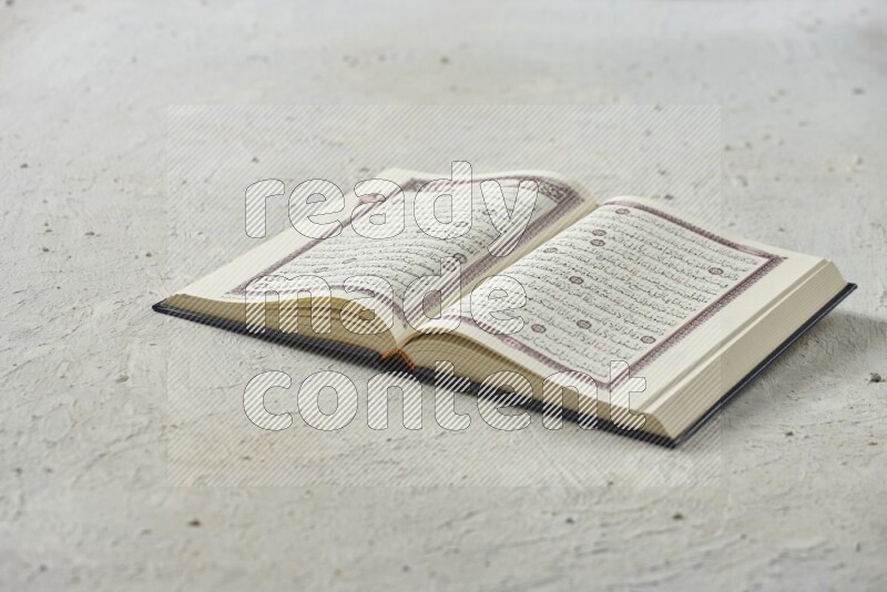 Quran with dates, prayer beads and different drinks all placed on textured white background