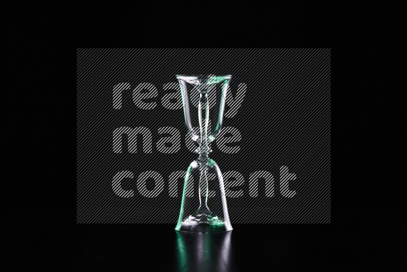 Glassware with rim light in green and white against black background