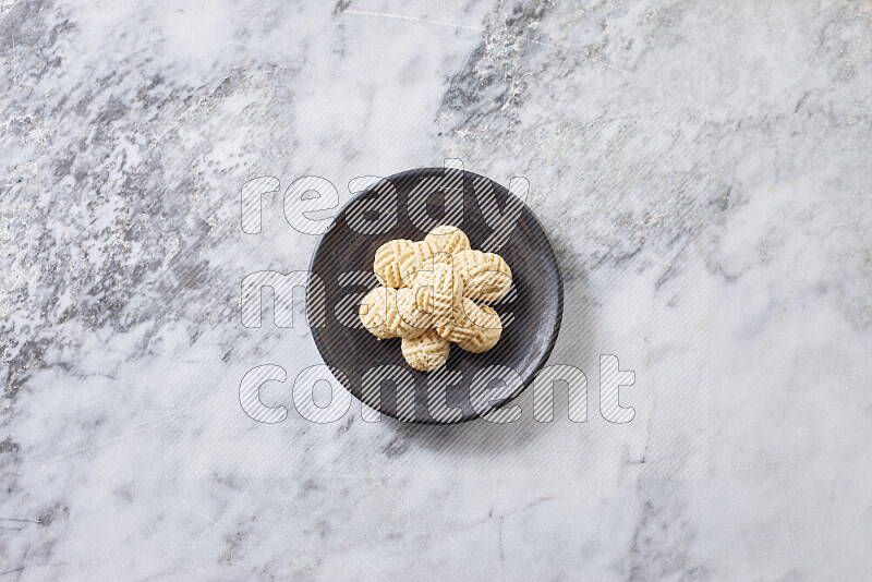 Kahk in black pottery plate on grey marble background