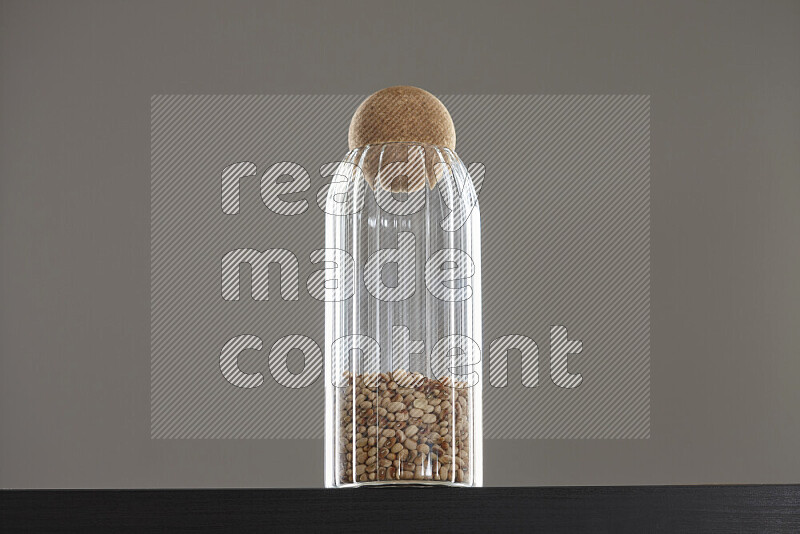 Black-eyed peas in a glass jar on black background