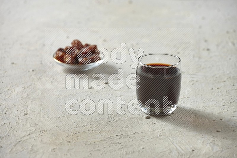 Cold drinks in a glass cup with dates such as water, tamarind, qamar eldin, sobia, milk and hibiscus on textured white background