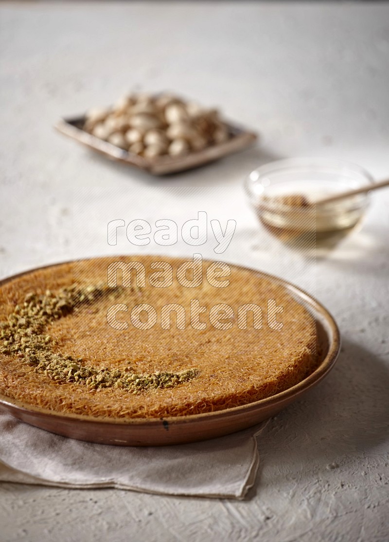 Konafa with nuts and honey in a light setup