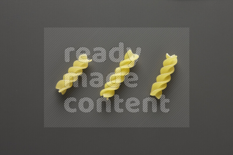 Fusilli pasta on grey background