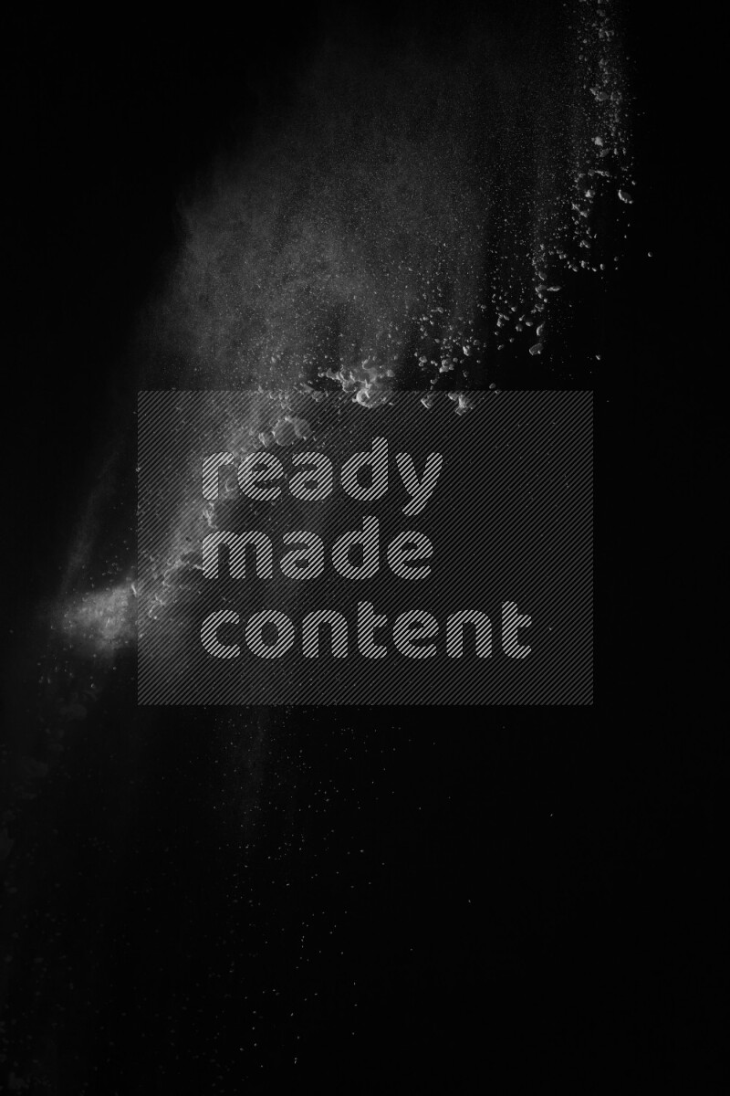 A side view of white powder explosion on black background