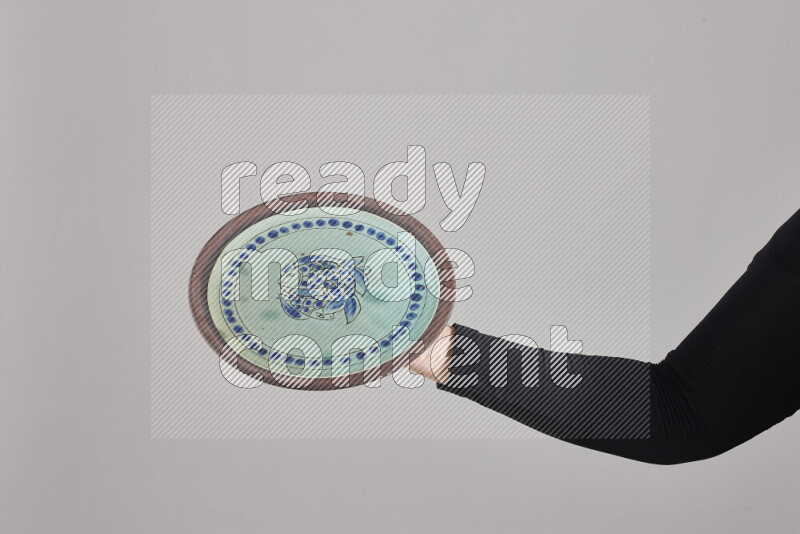 A woman in black abaya holding different pottery essentials in different positions