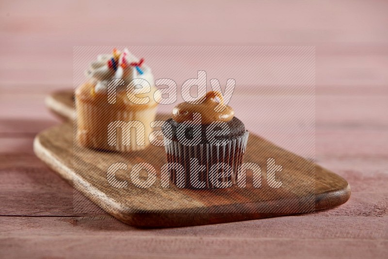Chocolate mini cupcake topped with peanut butter on a wooden board