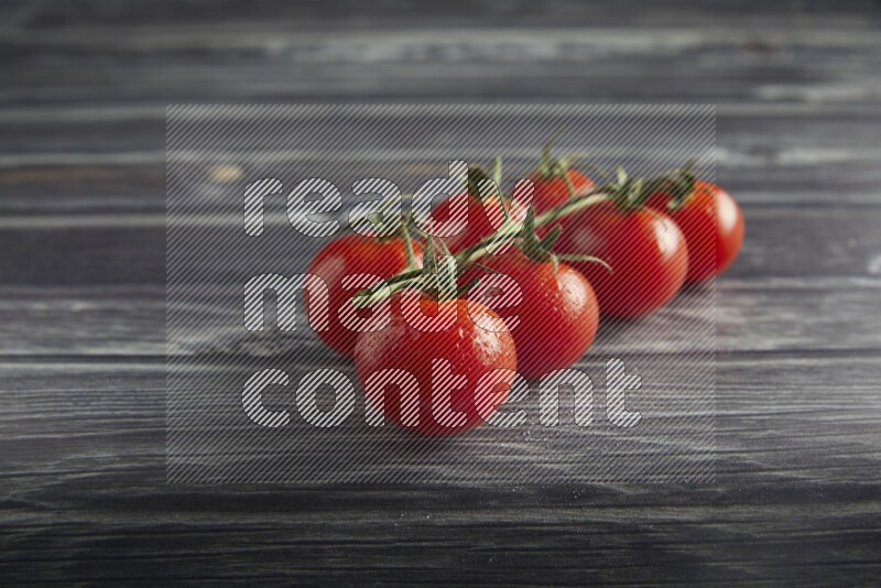 Red cherry tomato vein on a textured grey wooden background 45 degree