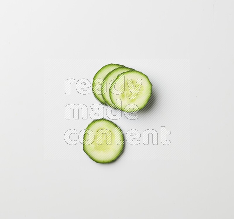 Multiple cucumber slices on white background