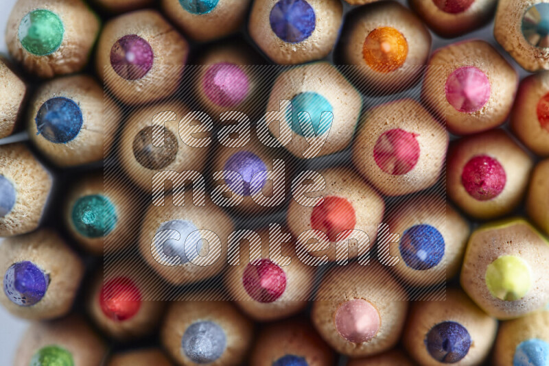 The image captures top view shot of sharpened colored pencils on grey background