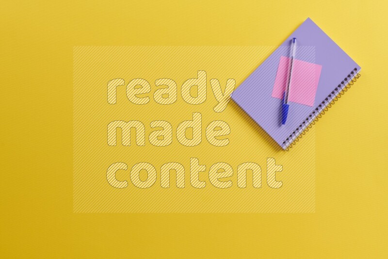 دفتر إرجواني مع مستلزمات مدرسية مختلفة على خلفية صفراء