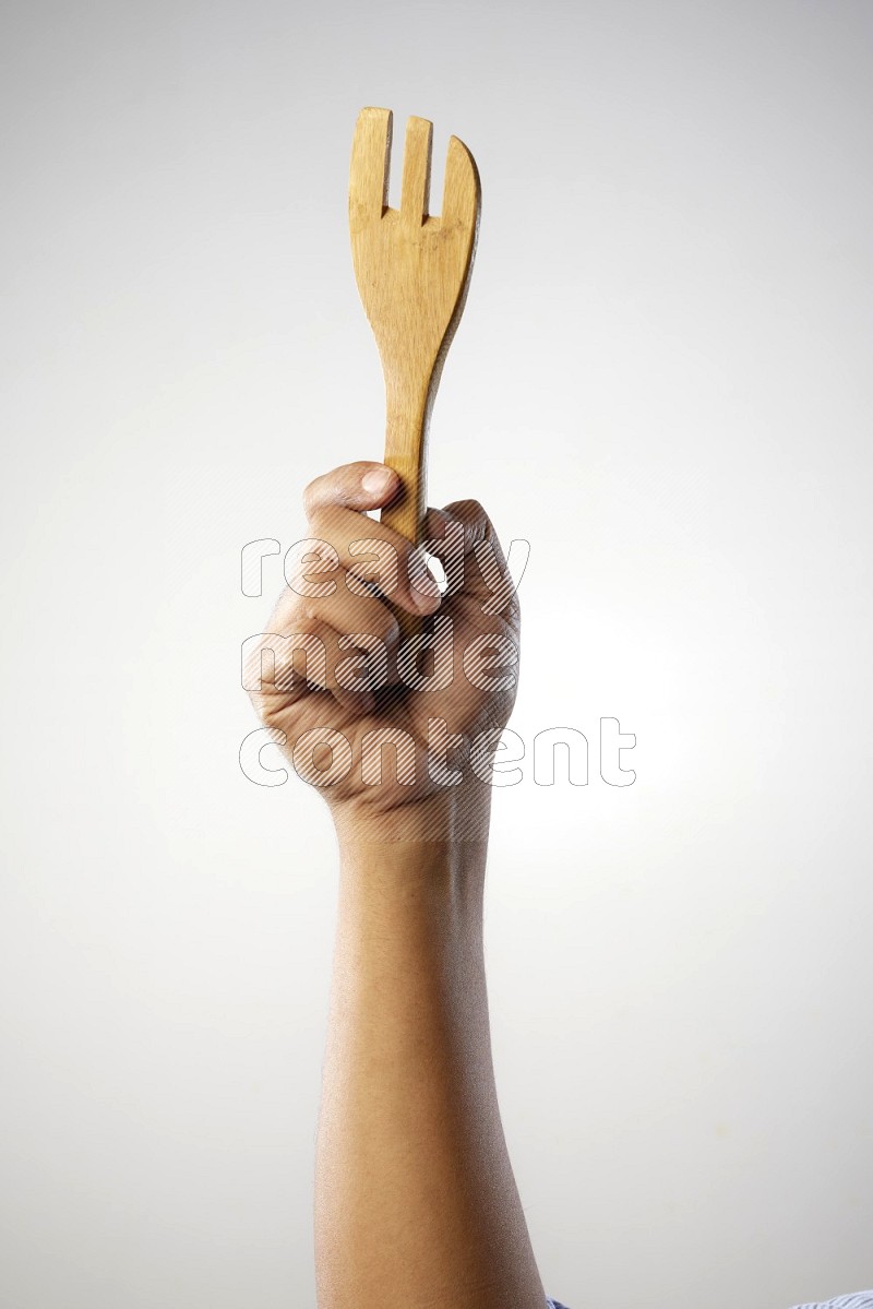 Male Hand Holding Wooden Fork on white  background
