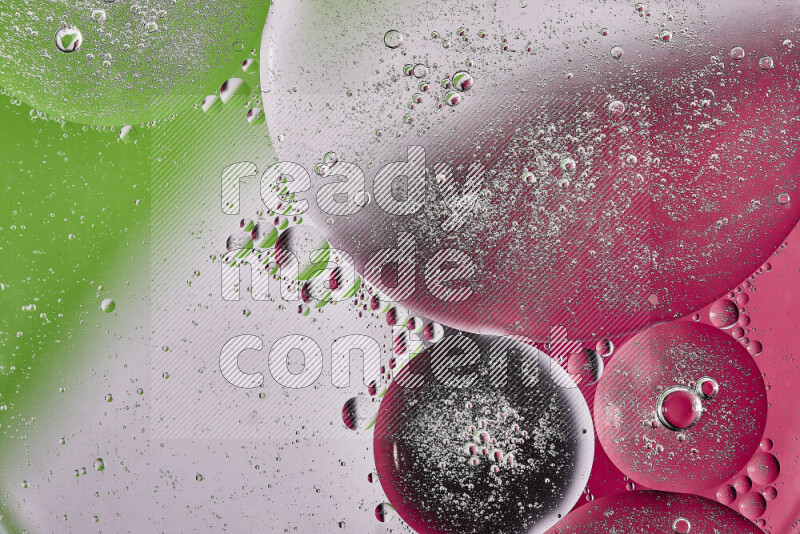 Close-ups of abstract oil bubbles on water surface in shades of pink, green and white