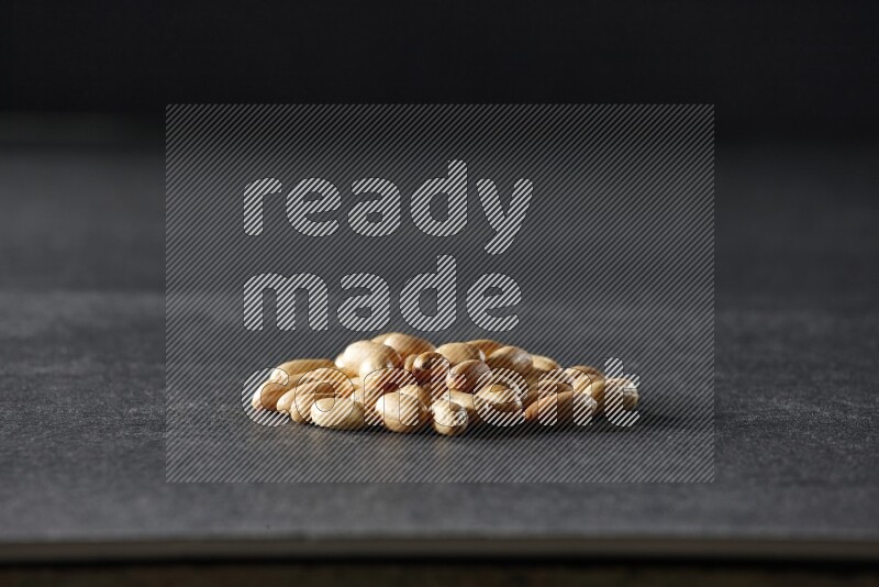 مجموعة من حبات الفول السوداني المقشرعلي خلفية سوداء