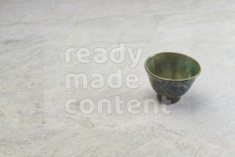 A multicolored pottery bowl on grey marble background