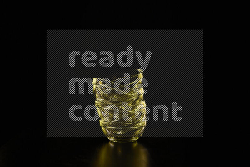 Glassware with rim light in yellow against black background